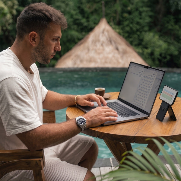 Digital nomad som jobbar vid poolen på laptop med portabel skärm