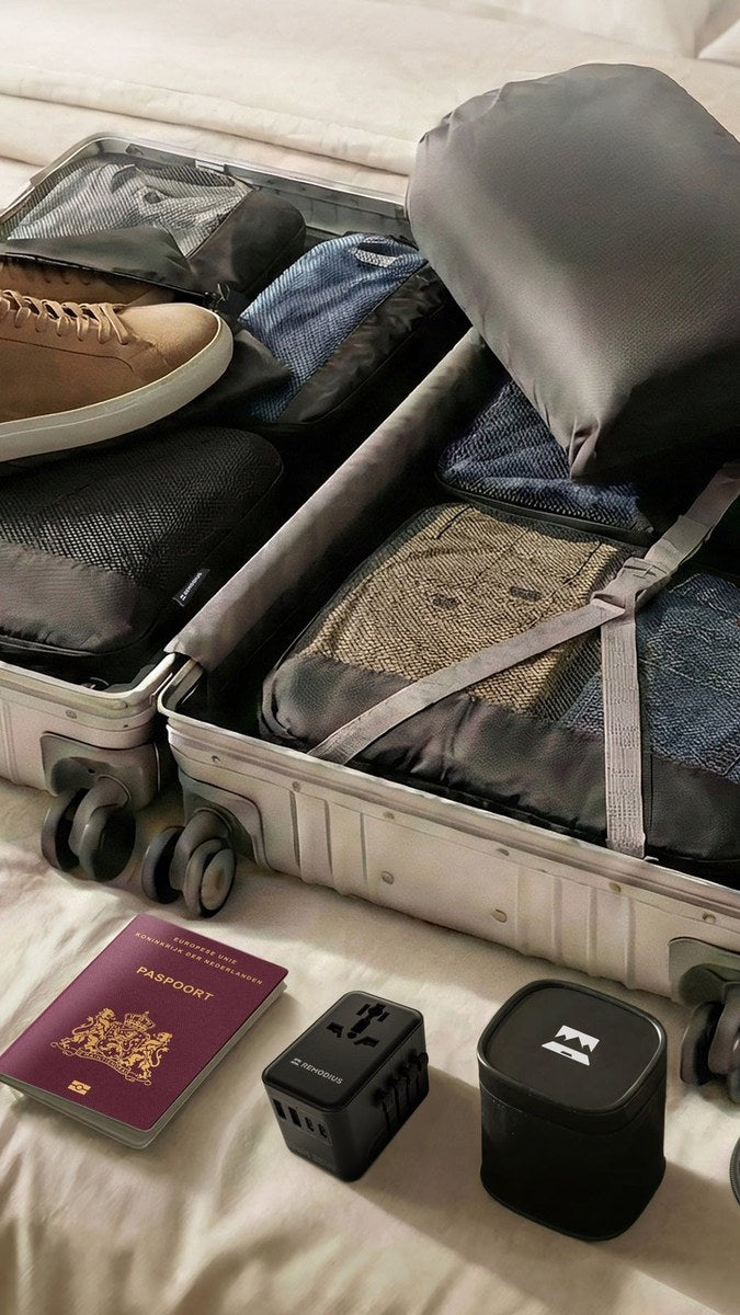 Koffer met packing cubes, wereldstekker, oplaadkabels en paspoort